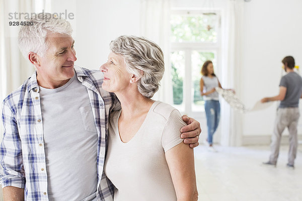 Älteres Paar lächelt zusammen im Wohnraum