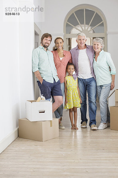 Familie lächelt gemeinsam im Wohnraum