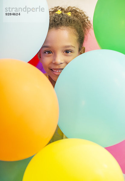 Junges Mädchen umgeben von Luftballons