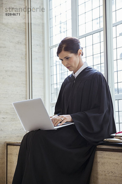 Richter auf der Bank sitzend mit Laptop im Gerichtsgebäude