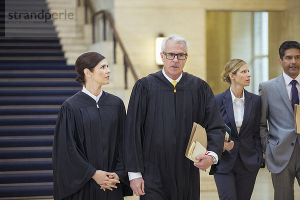 Richter und Anwälte gehen durch das Gerichtsgebäude.