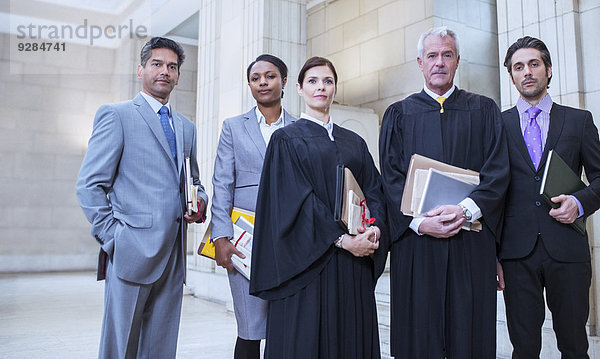 Richter und Anwälte stehen zusammen im Gerichtsgebäude.