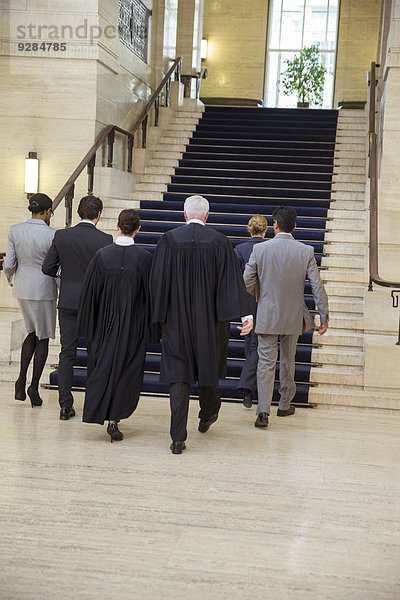 Richter und Anwälte gehen gemeinsam durchs Gerichtsgebäude.