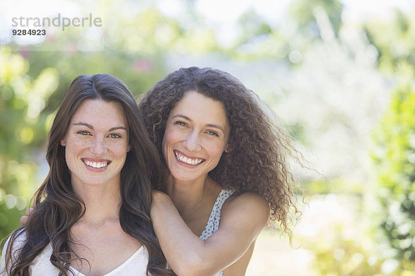 Schwestern lächeln gemeinsam im Freien