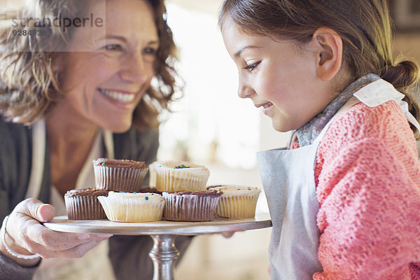 Großmutter bietet Enkelin Muffins an