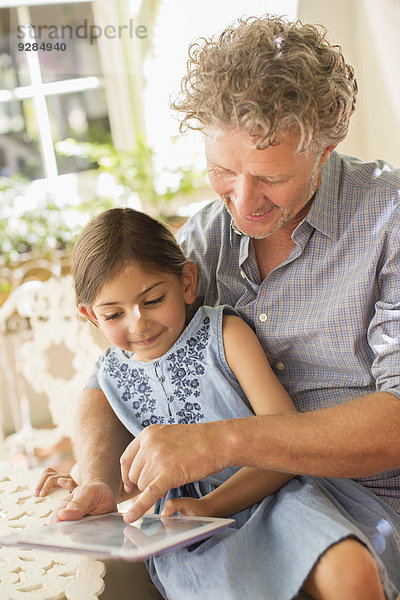 Großvater und Enkelin nutzen gemeinsam das digitale Tablett
