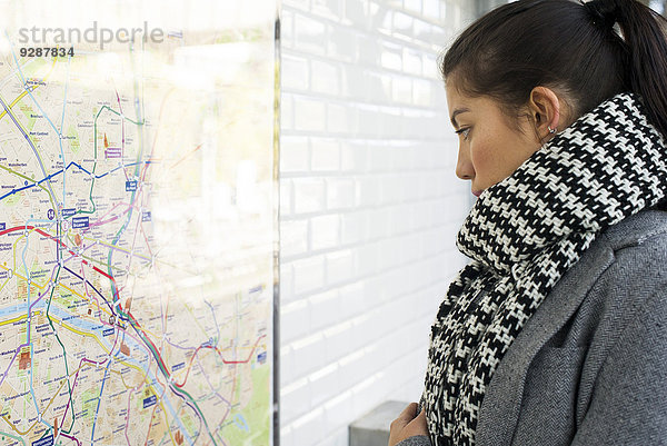 Frau schaut auf die Karte der öffentlichen Verkehrsmittel