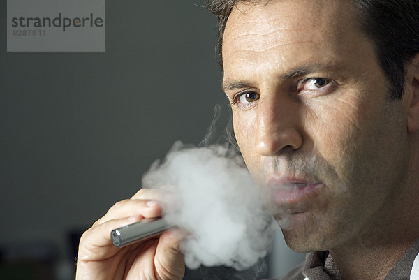 Mann raucht elektronische Zigarette