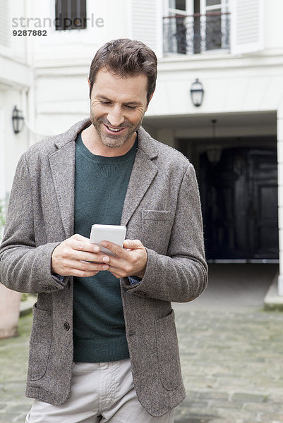 Geschäftsmann mit Smartphone unterwegs