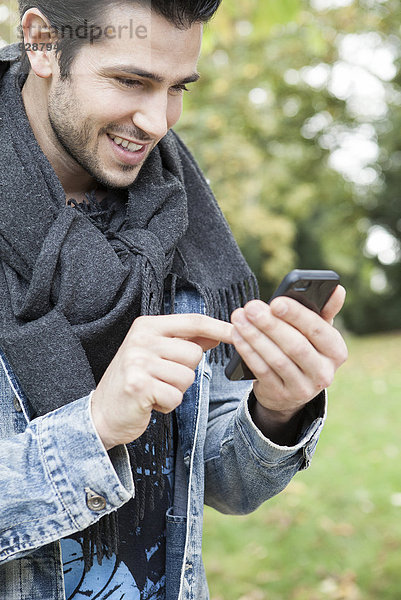 Junger Mann mit Smartphone im Freien