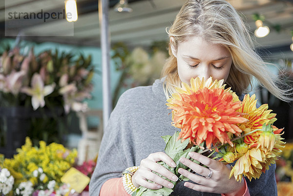 Junge Frau schätzt Blumenstraußduft