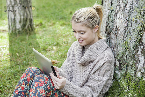Frau mit digitalem Tablett im Park