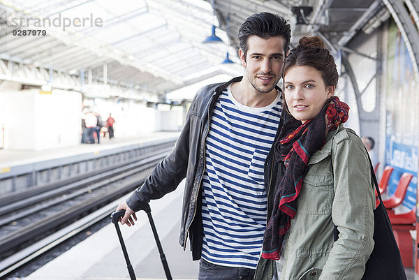 Paar mit Gepäck auf dem Bahnsteig