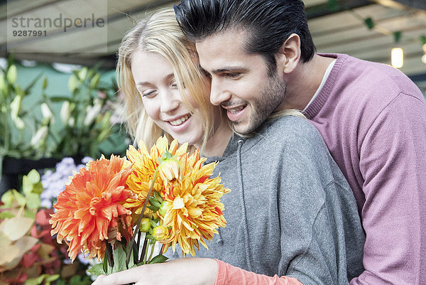 Mann erfreut Girlfiend mit Überraschungsgeschenk von Blumen