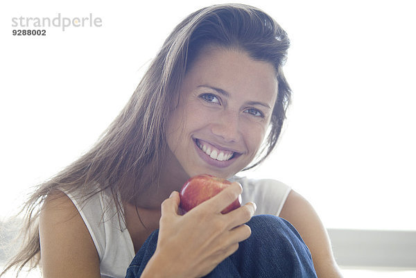Frau hält Apfel  lächelnd  Portrait