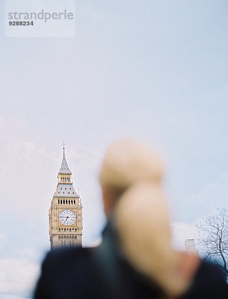 Eine Frau schaut zum Big Ben  dem Elizabeth-Tower im Houses of Parliament in London  auf.