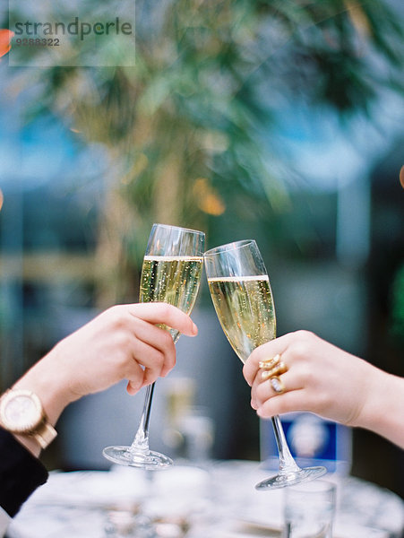 Zwei Frauen stoßen mit Champagnergläsern aufeinander an.