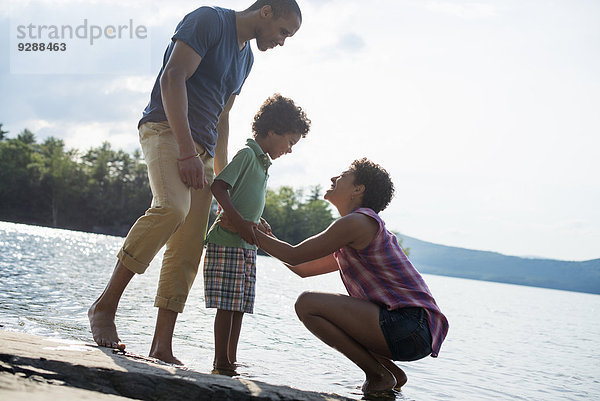 Eine Familie  Eltern und Sohn verbringen im Sommer gemeinsam Zeit an einem See.