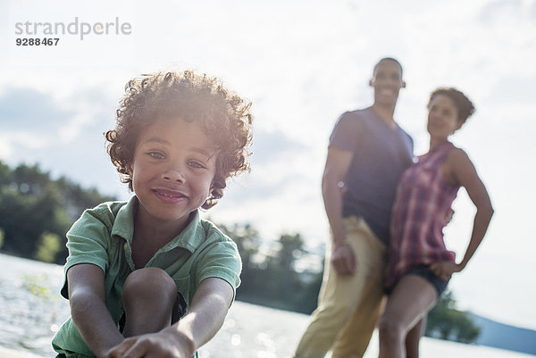 Eine Familie  Eltern und Sohn verbringen im Sommer gemeinsam Zeit an einem See.
