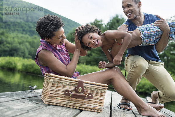 Eine Familie  die im Sommer ein Picknick an einem See macht.