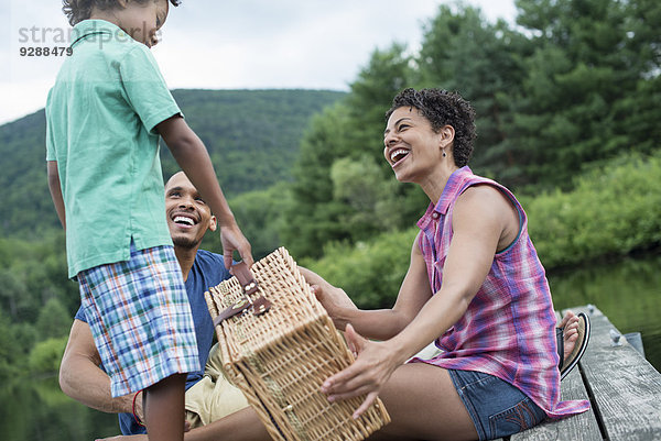 Eine Familie  die im Sommer ein Picknick an einem See macht.