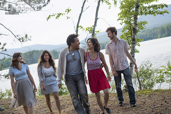 Eine Gruppe von Menschen  die einen gemütlichen Spaziergang an einem See genießen.