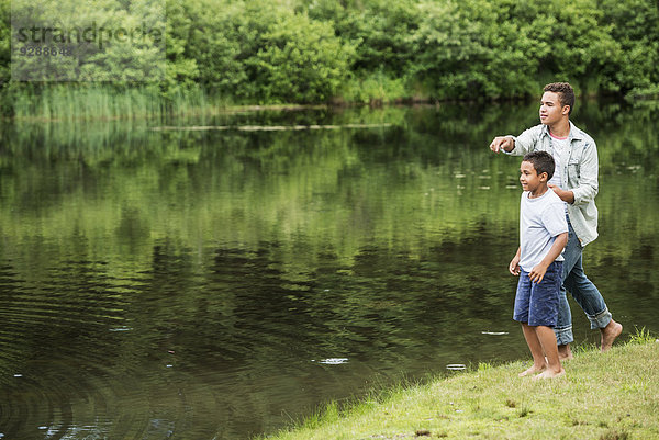 Zwei Brüder spielen an einem See.