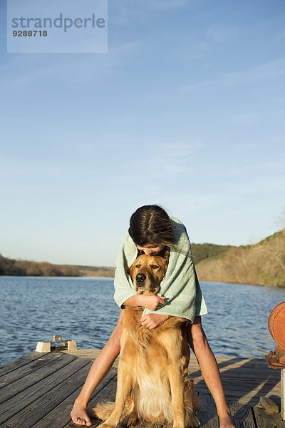Ein Mädchen kuschelt mit einem Golden Retriever-Hund.