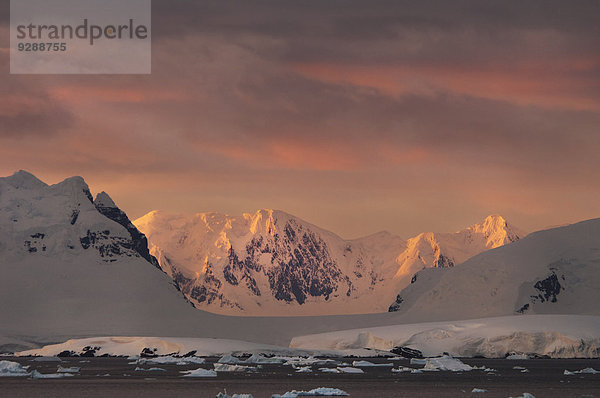 Sonnenuntergang über der gebirgigen Landschaft der Antarktis.
