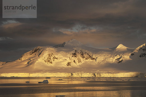 Sonnenuntergang über der gebirgigen Landschaft der Antarktis.