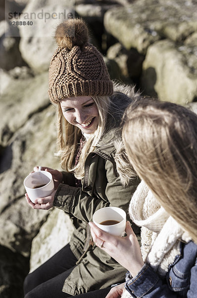 Zwei Mädchen beim Winterpicknick am Strand.