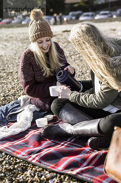 Zwei Mädchen beim Winterpicknick am Strand.