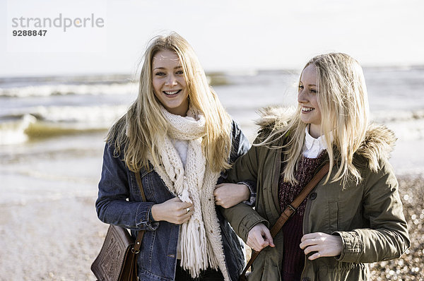 Zwei junge Mädchen an einem Strand im Winter.