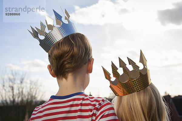 Zwei Kinder in Kostümen  die Kronen tragen.