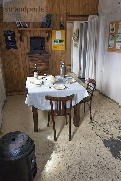 Das Innere der wissenschaftlichen Forschungsstation in Camp Livingston auf den Süd-Shetland-Inseln. Ein Esstisch und Stühle mit Gedecken.