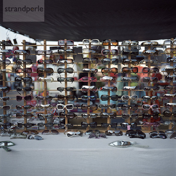 Eine große Auswahl an Sonnenbrillen zum Verkauf auf einem Flohmarkt