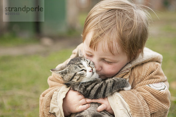 Kleines Mädchen mit Katze und Küssen