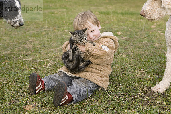 Kleines Mädchen spielt mit Katze