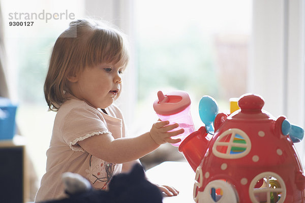 Kleines Mädchen spielt zu Hause mit Spielzeug