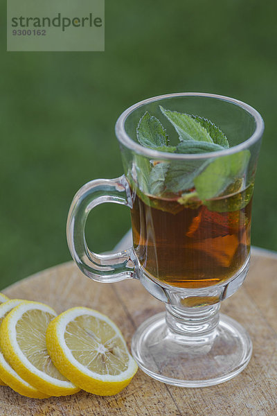 Eistee mit Minze durch Limettenscheiben auf dem Außentisch