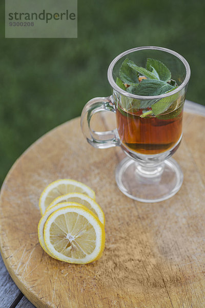 Eistee mit Minze durch Limettenscheiben auf dem Außentisch