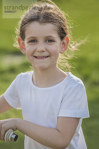 Portrait süßes lächelndes Mädchen mit Fahrrad im Park