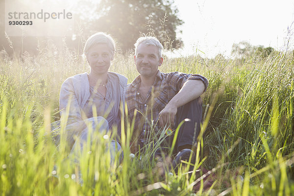 Porträt eines lächelnden reifen Paares  das eine Pause von der Gartenarbeit macht