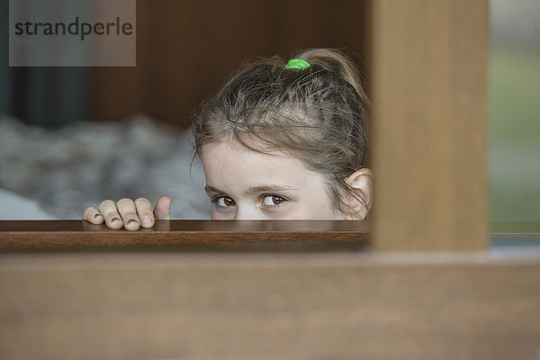 Porträt eines Mädchens  das durchs Fenster schaut