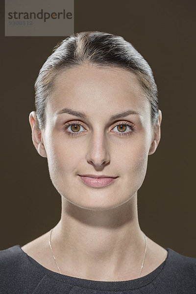 Porträt einer jungen Frau vor braunem Hintergrund