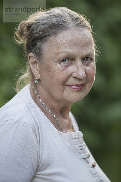 Seitenansicht Porträt einer älteren Frau  die im Freien lächelt