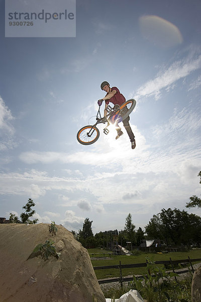Ein BMX-Fahrer  der einen Stunt in der Luft macht.