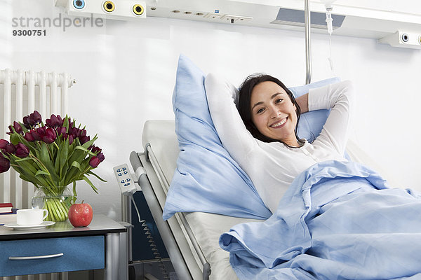 Ein fröhlicher Patient liegt in einem Krankenhausbett.
