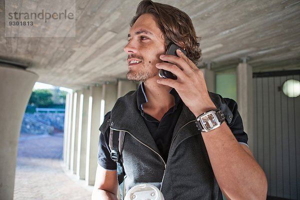 Mittlerer Erwachsener Mann beim Chatten auf dem Smartphone in der Stadtunterführung