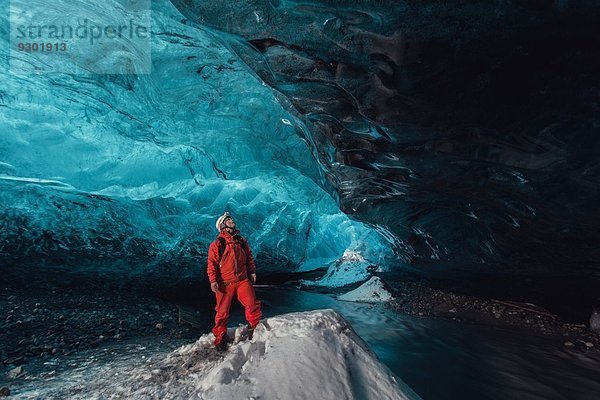 Mann blickt aufwärts in die Eishöhle  Vatnajokull Gletscher  Vatnajokull Nationalpark  Island